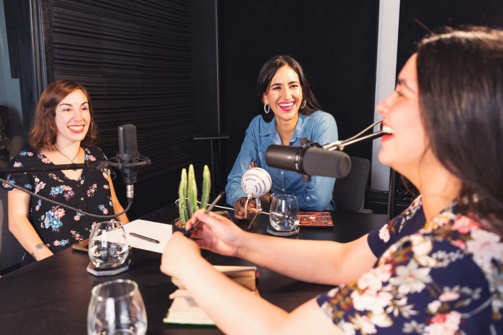 Women Sitting at a Table recording a podcast
